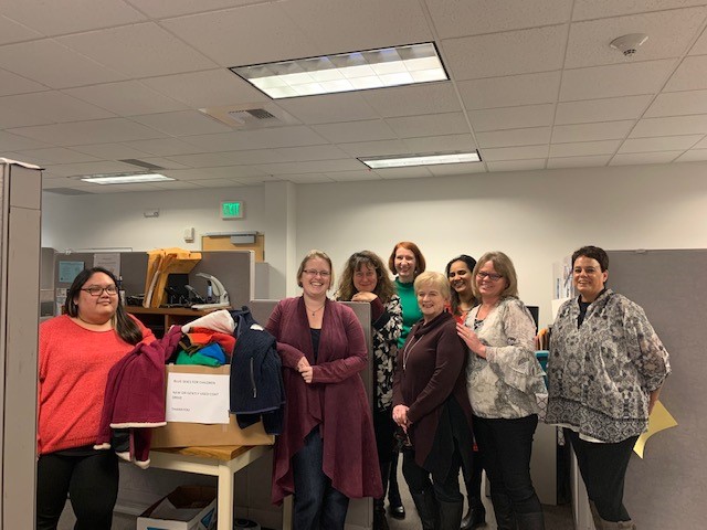 Warm Coat Drive 2019 - Photo of the Contracts & Procurement Team with Coats