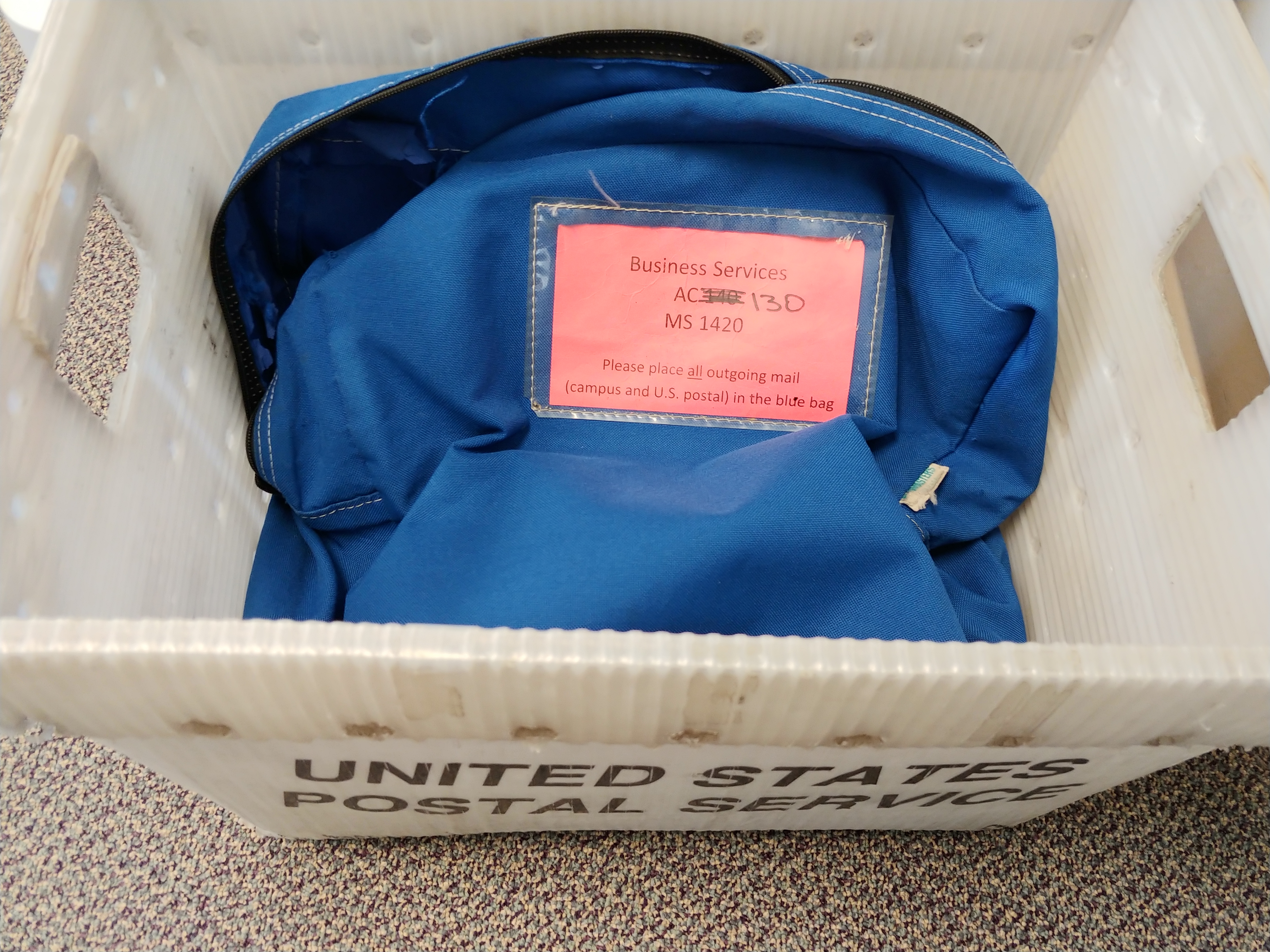 blue postal bag within a mail carrier box