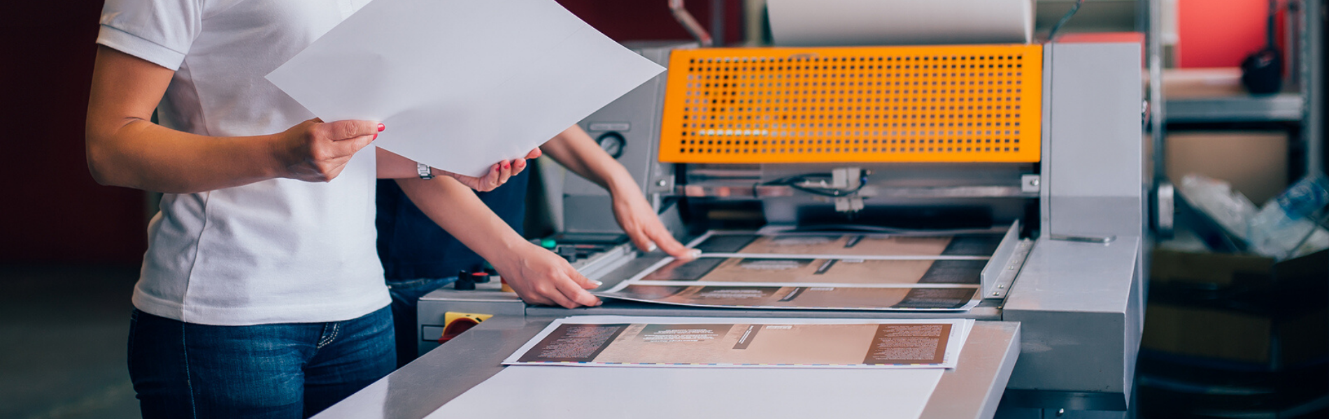 Close up of two people reviewing the output of a large format printer